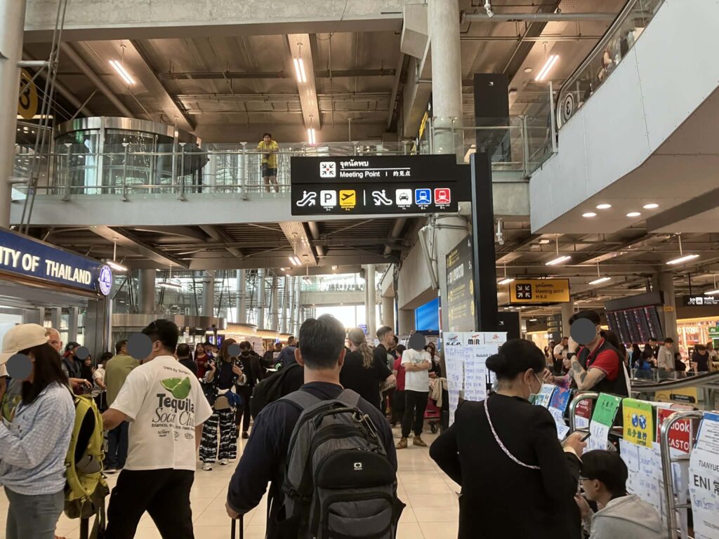 Crowded arrival lobby at Suvarnabhumi Airport during peak hours