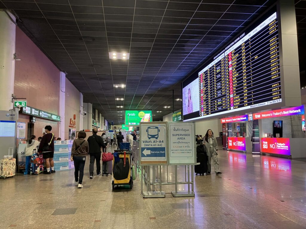 Don Mueang Airport arrivals hall with signs for airport buses