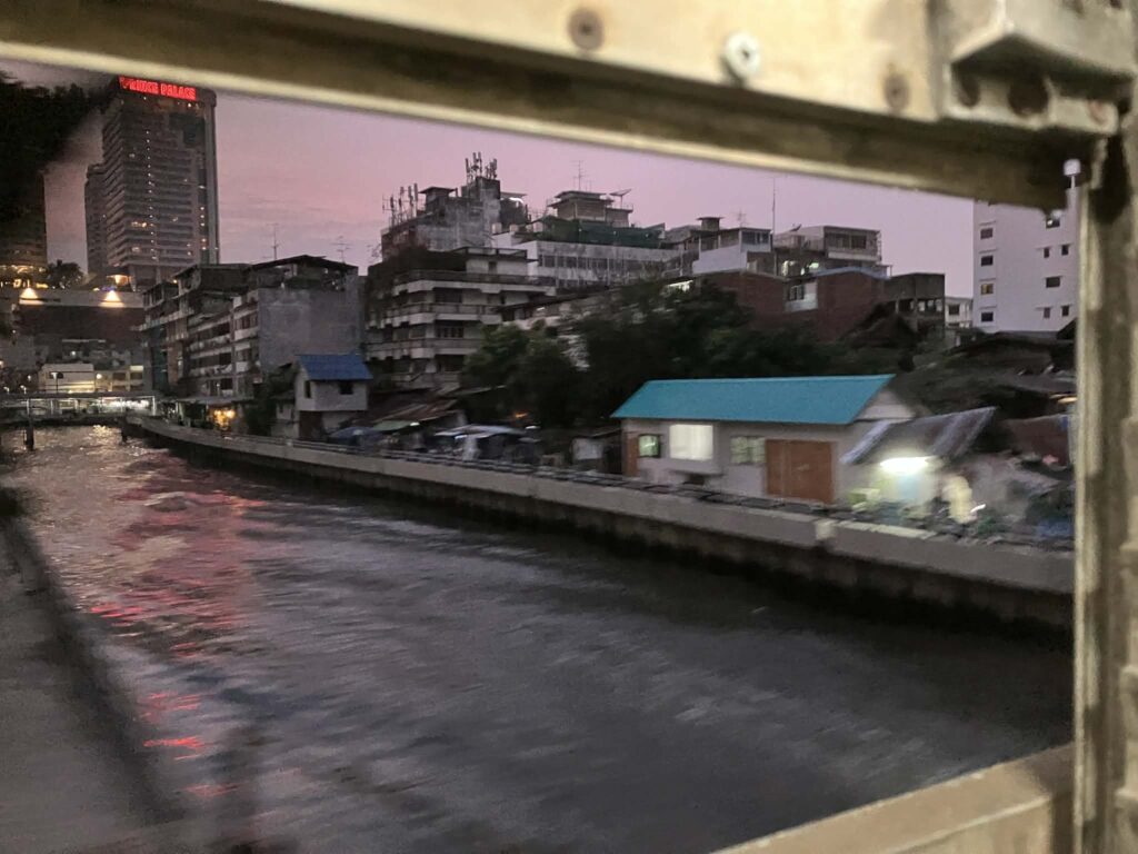 View from a local train window in Bangkok at sunset