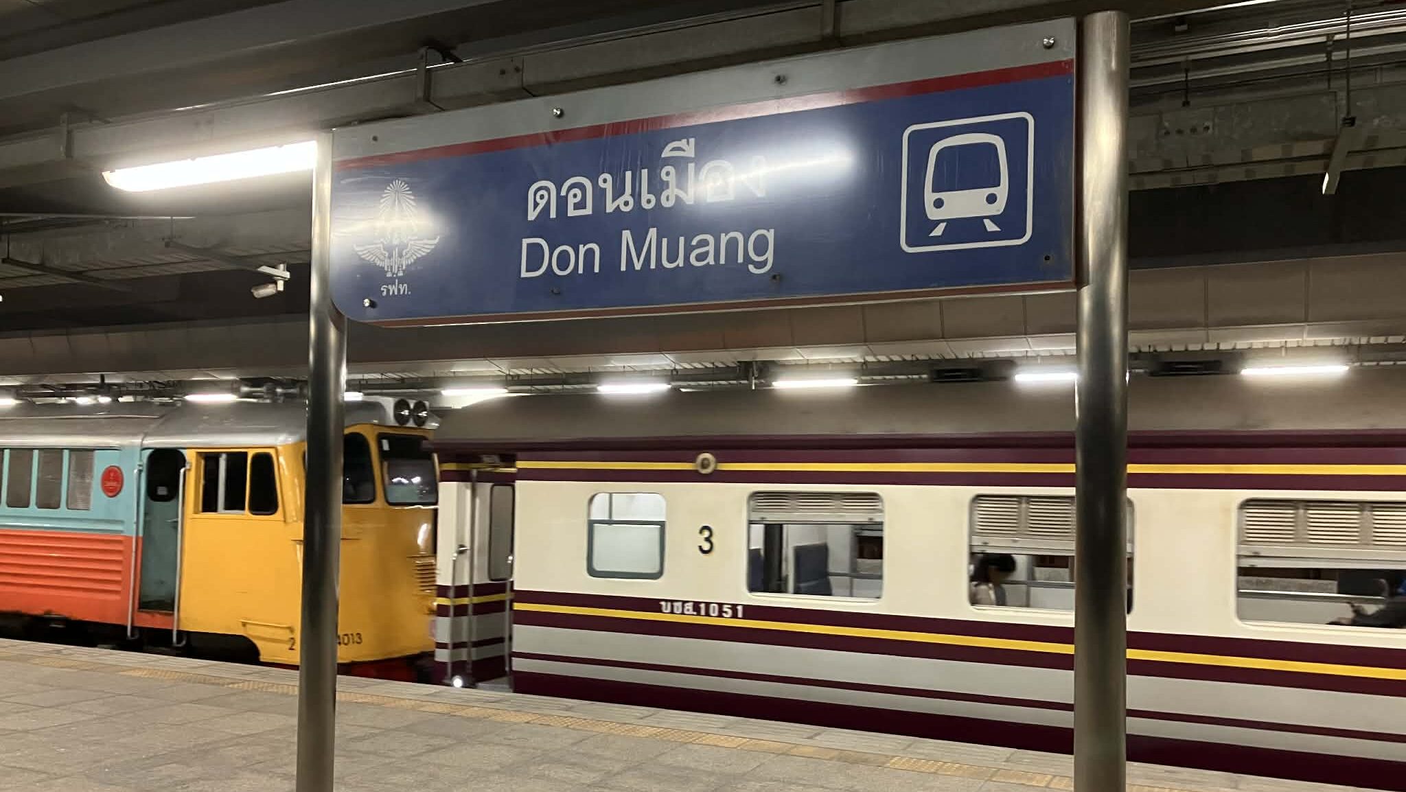 Don Mueang railway station sign above a local train platform in Bangkok